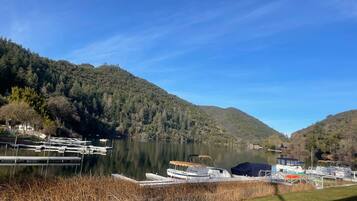 A lakeside dock with boats, surrounded by forested hills.