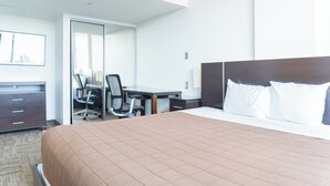 A hotel room with a bed, a desk, a chair, and a wardrobe. - University of Calgary Accommodations & Events (Calgary)