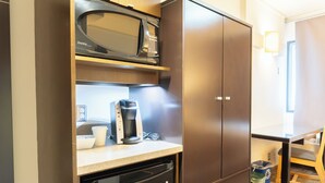 A compact kitchen with a microwave, coffee maker, and dishwasher. - University of Calgary Accommodations & Events (Calgary)