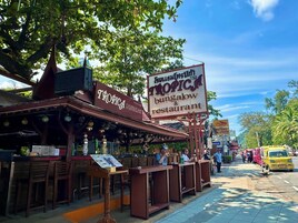 Restaurante llamado Tropica con terraza y un letrero que anuncia bungalows y restaurante.