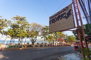 Ravintola nimeltä ”Bullshmin Tropic”, ja kyltin taustalla näkyy ranta ja palmuja.