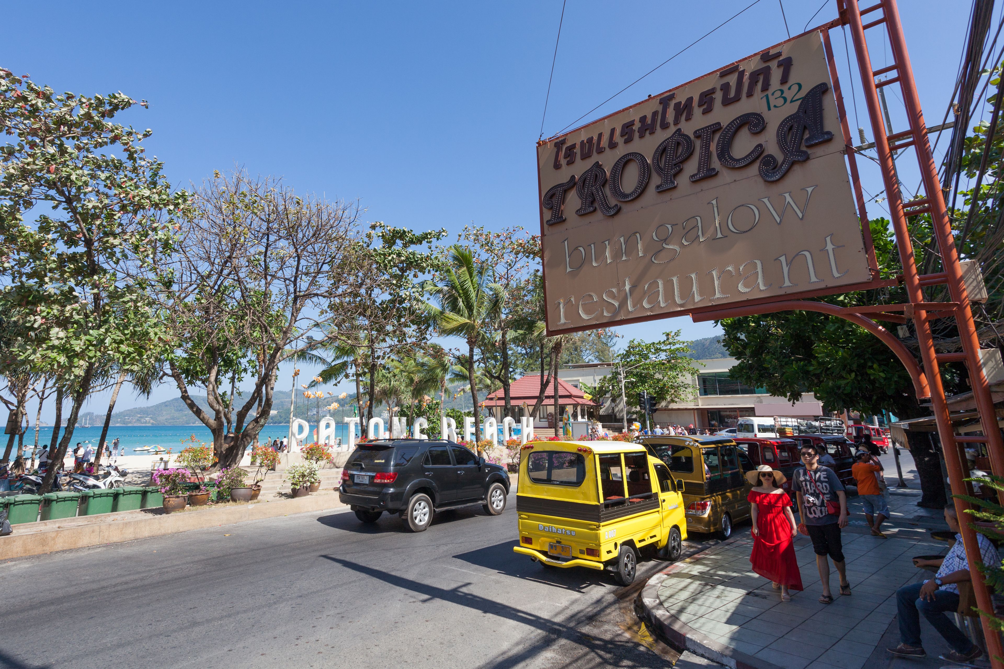 Vista de una calle con un letrero que anuncia el restaurante Tropical Bungalow Restaurant.