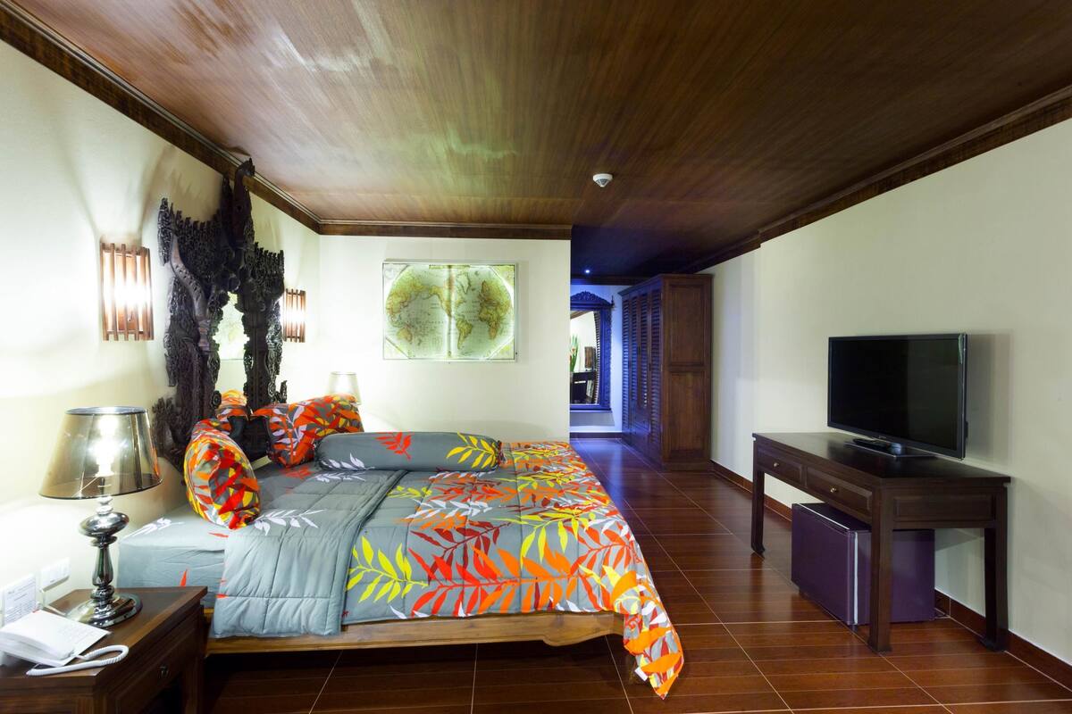 A bedroom with a bed, a television, and a desk.