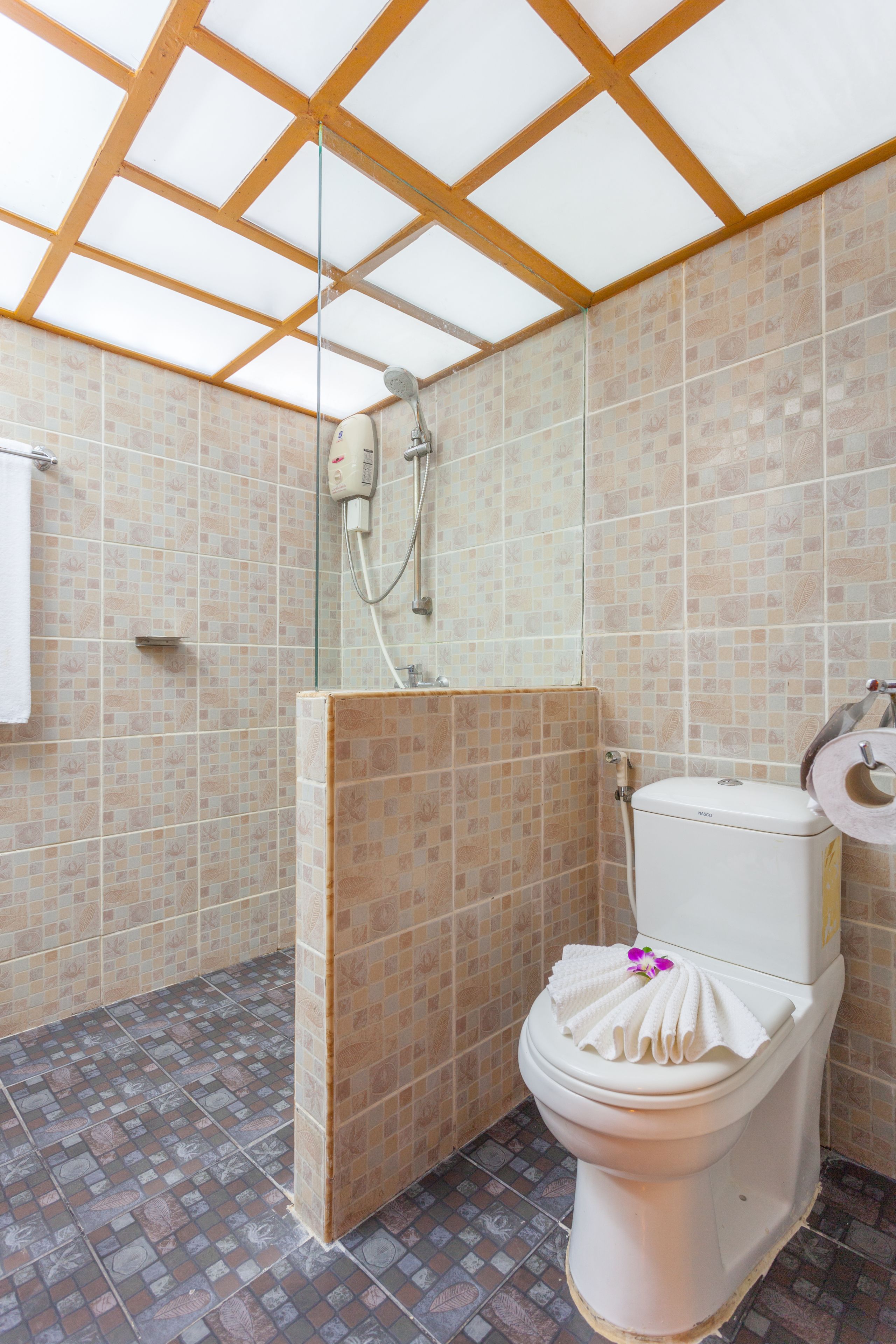 A bathroom with a shower, toilet, and tiled walls.
