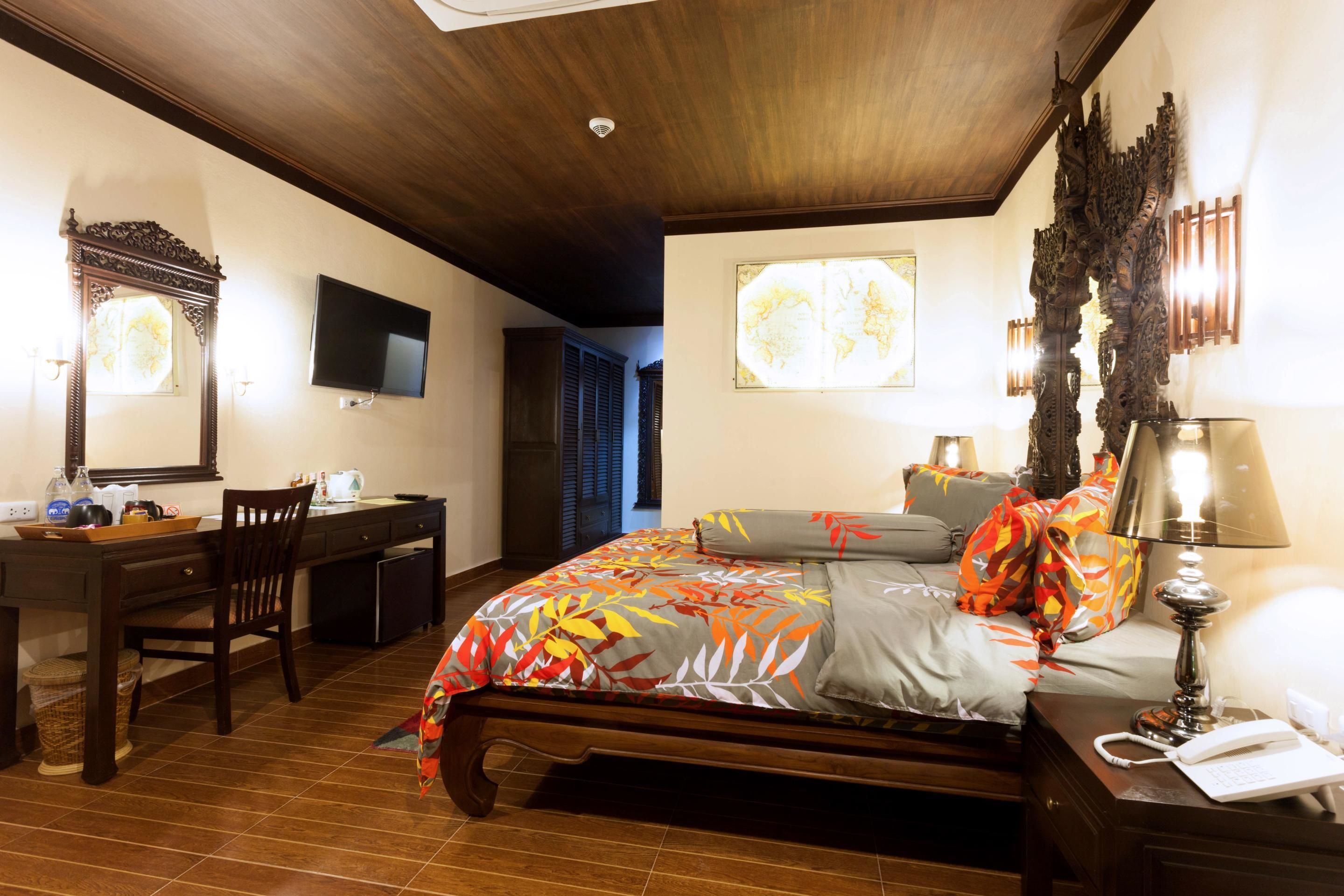 Une chambre à coucher avec un lit en bois, un bureau, une chaise, une télévision et une lampe.