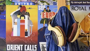 Una persona con auriculares, con un cartel de fondo que muestra 'ORIENT CALLS' y 'WASHINGTON'.