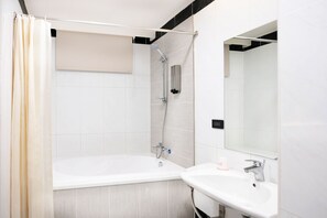Combined shower/bathtub, hair dryer, slippers, towels