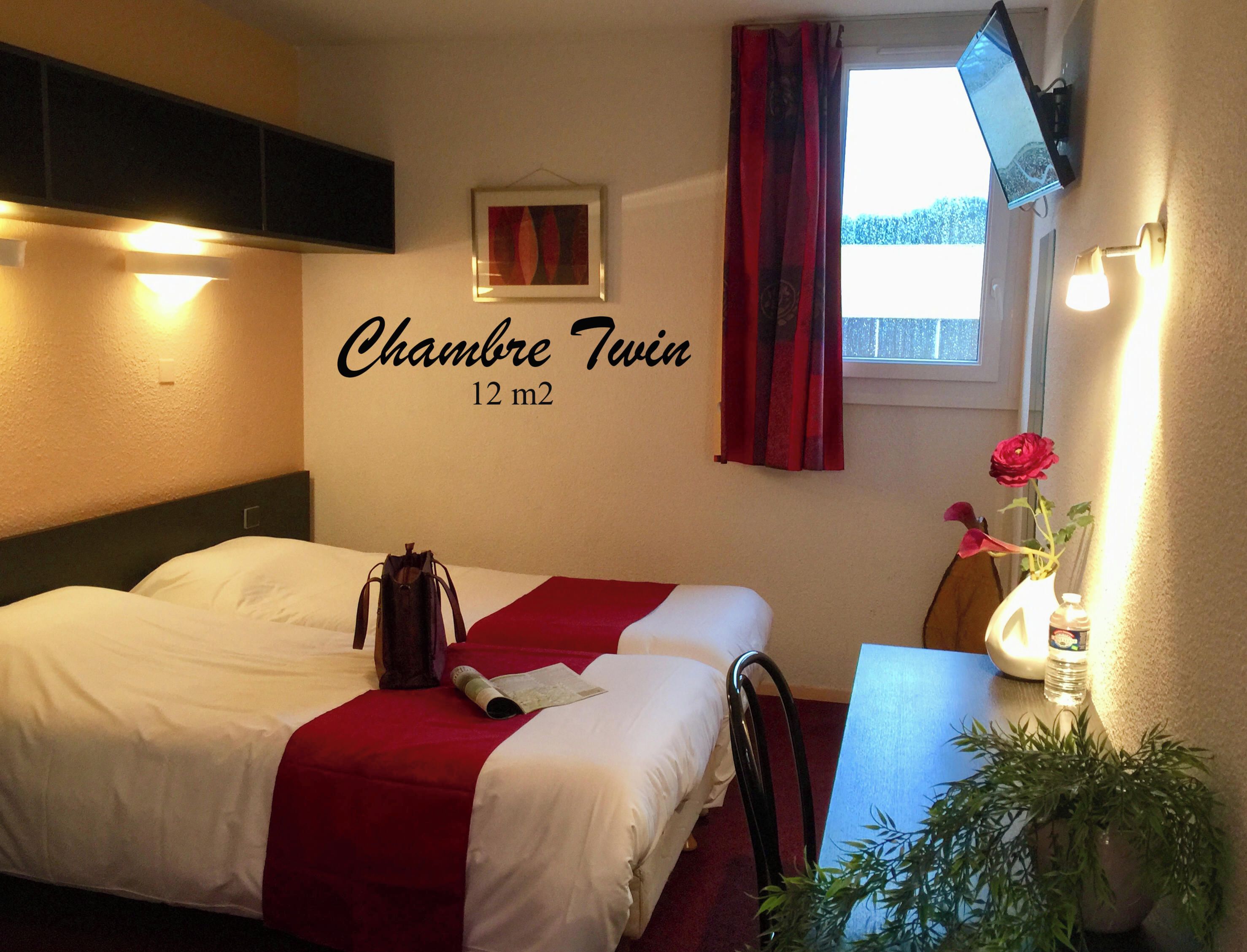 A twin room with a bed, a desk, a TV, a window with curtains, and a wall-mounted sign indicating the room size.