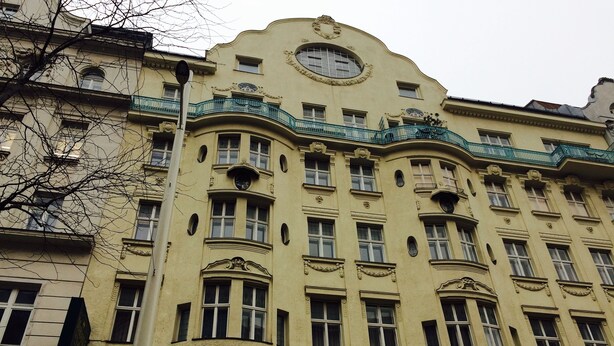 Un bâtiment historique doté de détails architecturaux raffinés, de nombreuses fenêtres et d’une horloge bien visible.