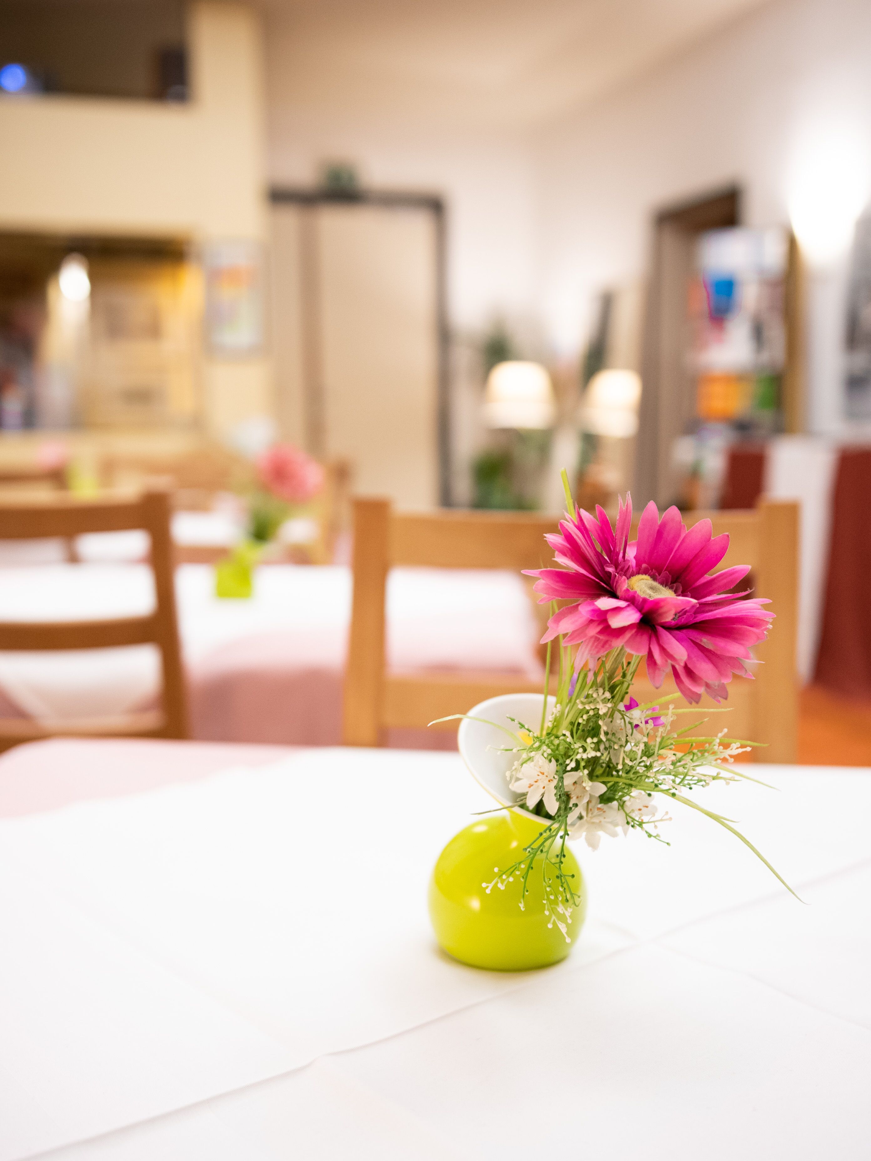 Ein Essbereich mit einem Tisch, auf dem sich eine Vase mit Blumen befindet.