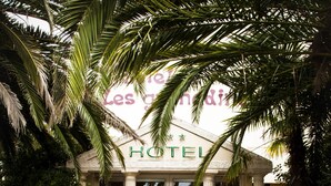 The entrance of Hotel Les Grenadines with a blue carpet featuring the hotel name and logo.