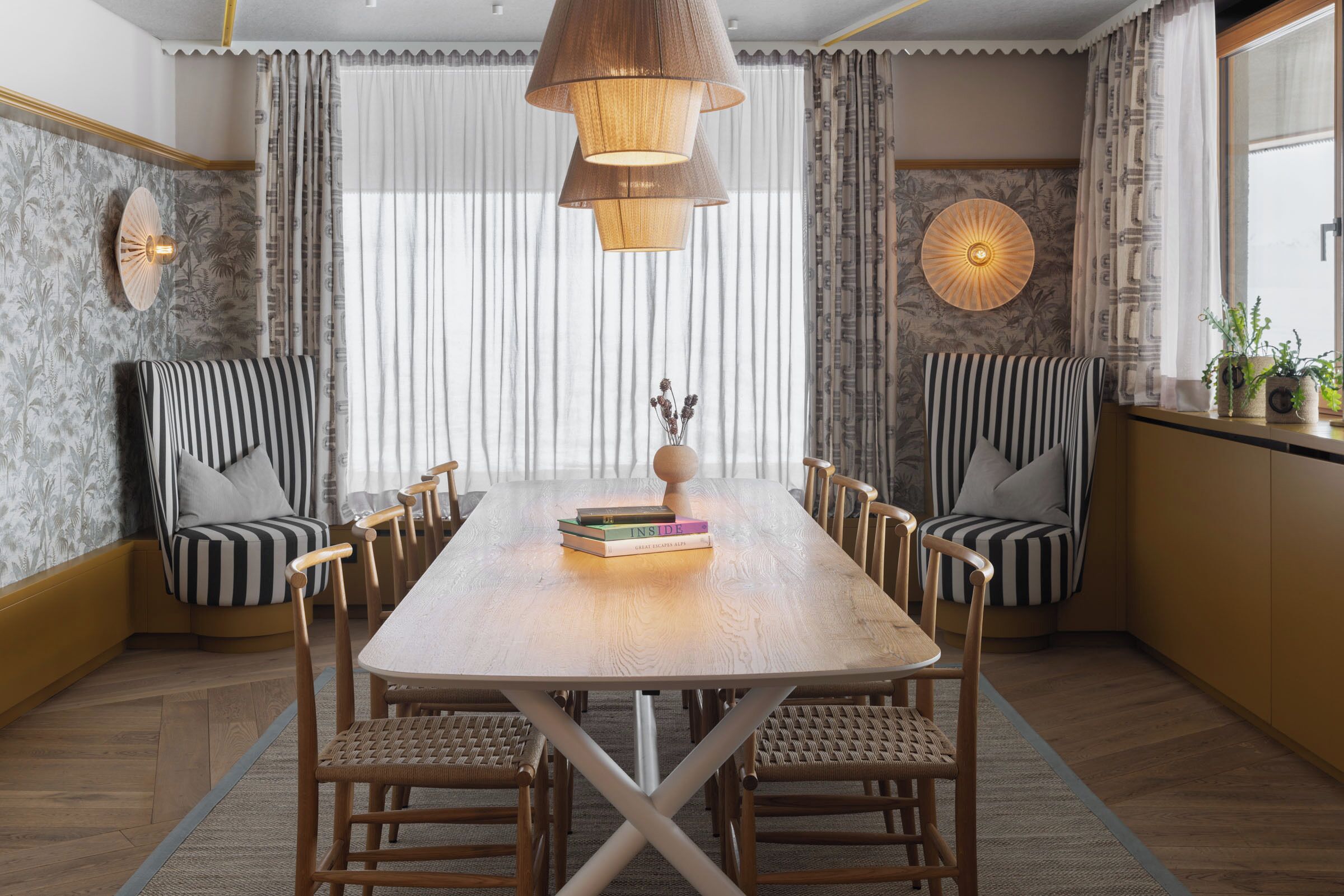 A dining area with a wooden table, six chairs, and a chandelier.