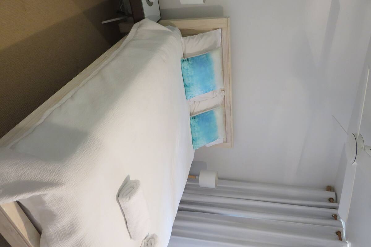 A hospital bed with a white mattress and a wooden headboard.