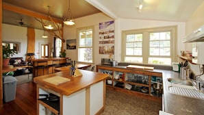 Una cocina con encimeras de madera, una isla central y un área de comedor con sillas y una mesa.