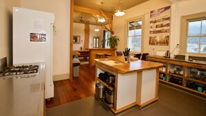 Una cocina con isla central, armarios de madera, refrigerador y estufa.