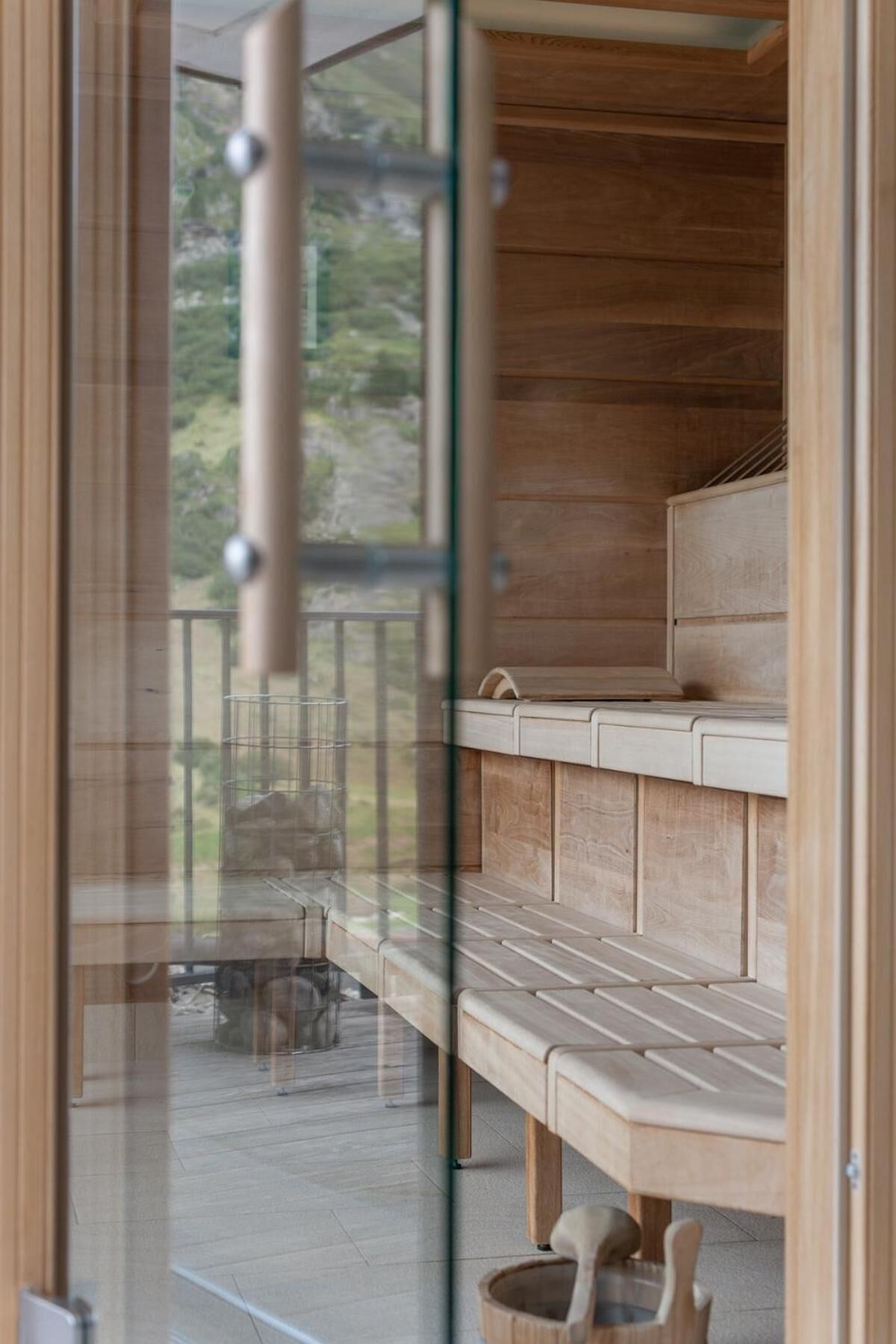 A modern interior with wooden paneling, a glass door leading to an outdoor area with a table and chairs.