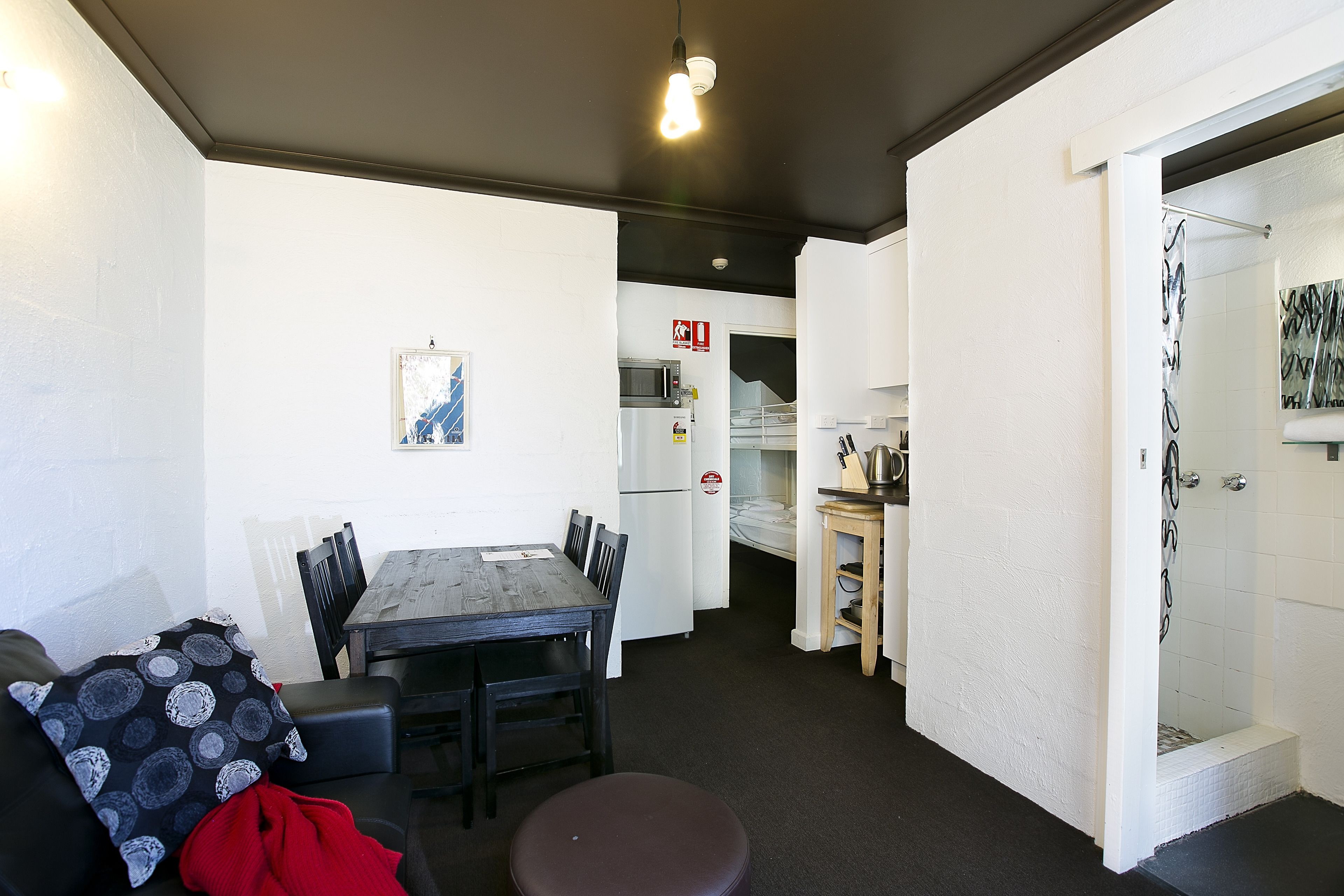 Un espacio habitable compacto con comedor, kitchenette y ducha.
