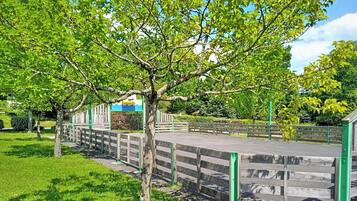 A park with a wooden fence, steps, and a tree.