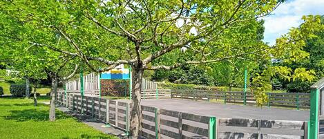 A park with a wooden fence, steps, and a tree.