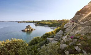 A coastal landscape with a prominent rocky outcrop and a small island. - Hôtel La Résidence (Roscoff)