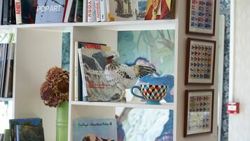 A bookshelf with books and decorative items, including a framed picture and a vase with dried flowers.