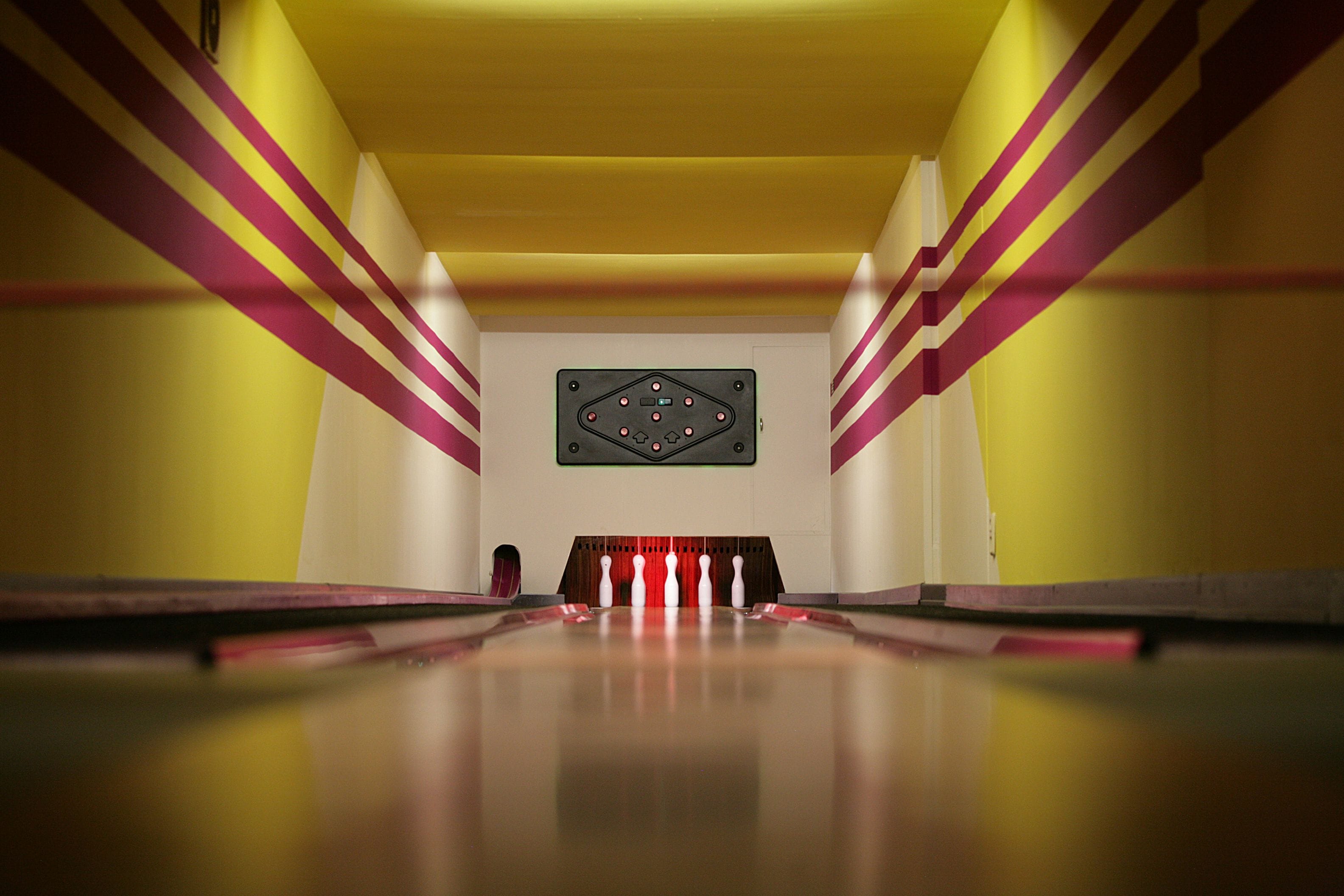 Una bolera con una pista larga y recta y un lanzador de bolos al final.