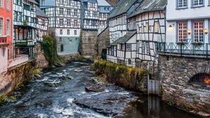 A narrow river running through a village with traditional half-timbered houses on both sides. - Hotel Mariaweiler Hof (Dueren)