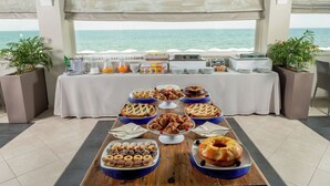 A buffet table with various food items and a view of the ocean. - Hotel Miramare (Latina)