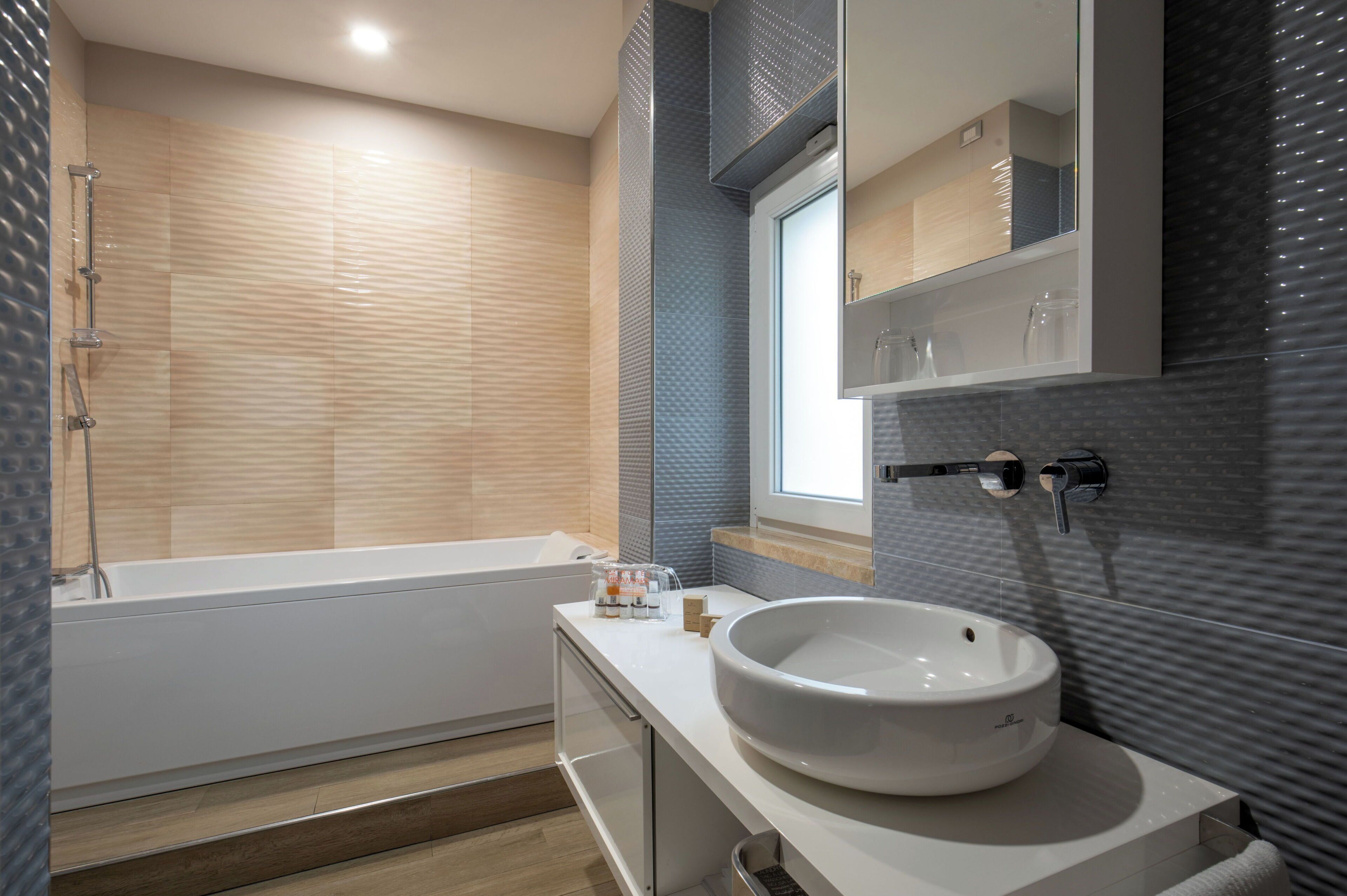 A modern bathroom with a bathtub, a large sink, and a mirror above the sink.