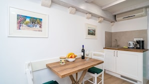Una cocina con una mesa de madera, armarios blancos y una lámpara colgante.