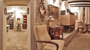 A spacious living area with a fireplace, comfortable seating, and a stone wall. - Hotel Villa Valdibora (Rovinj)