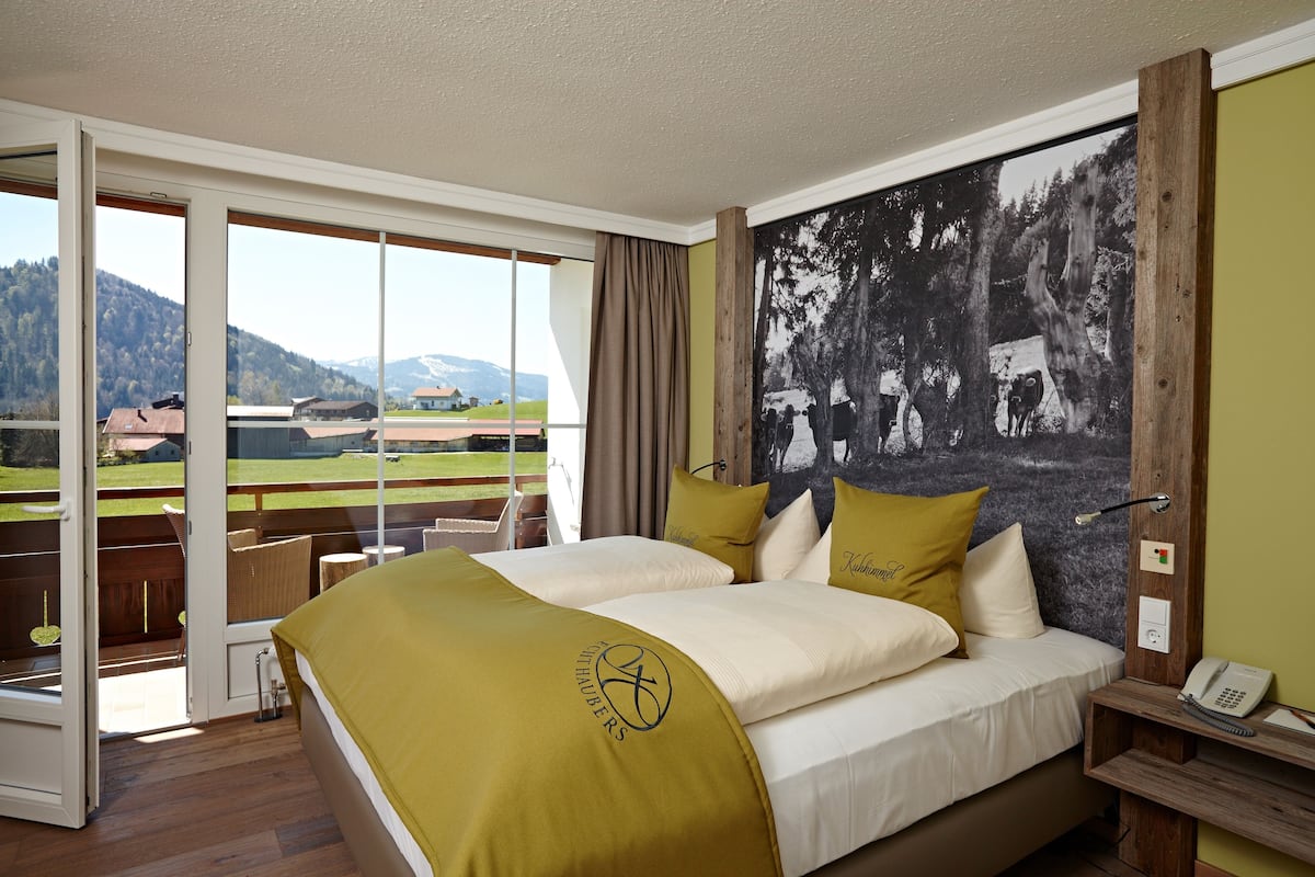 Une chambre d’hôtel avec un lit, un téléphone et une vue sur un terrain de golf.