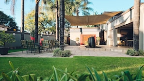 A patio area with outdoor seating, a water feature, and a covered section.