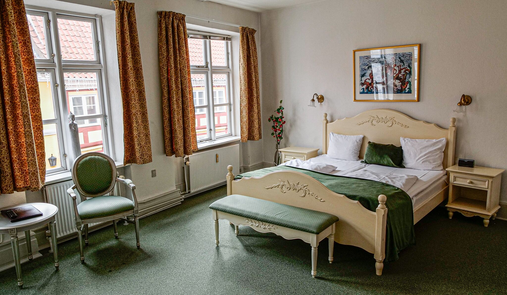 A classic bedroom with a bed, a chair, a bedside table, and a radiator.