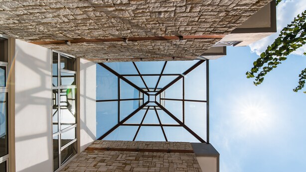 A modern building with a glass ceiling and a brick floor. - Vagelis Comfort Apartments (Hersonissos)