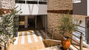 A modern building with a stone facade, large windows, and a central staircase. - Vagelis Comfort Apartments (Hersonissos)