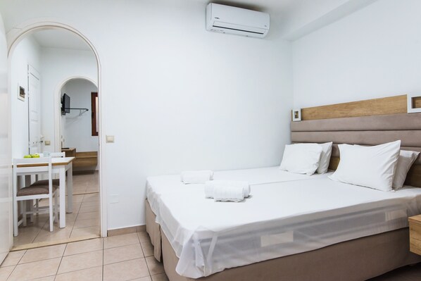 Una habitación de hotel con una cama, un escritorio y un equipo de aire acondicionado.