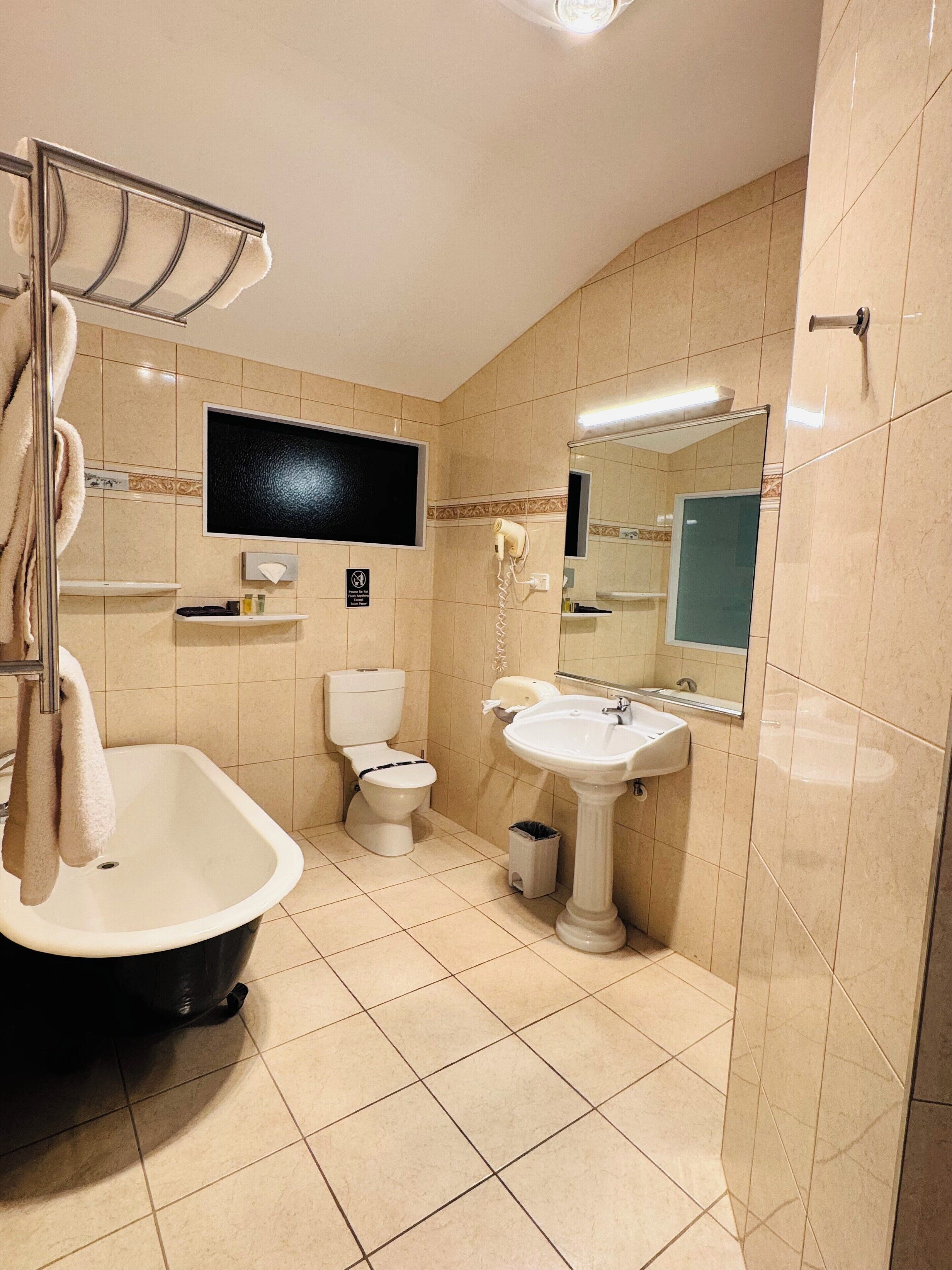 A bathroom with a bathtub, toilet, and sink.