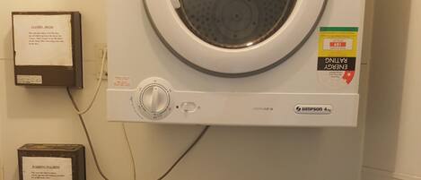 A front-loading washing machine with a Samsung control panel, a front-loading dryer, and a water conservation rating sticker.