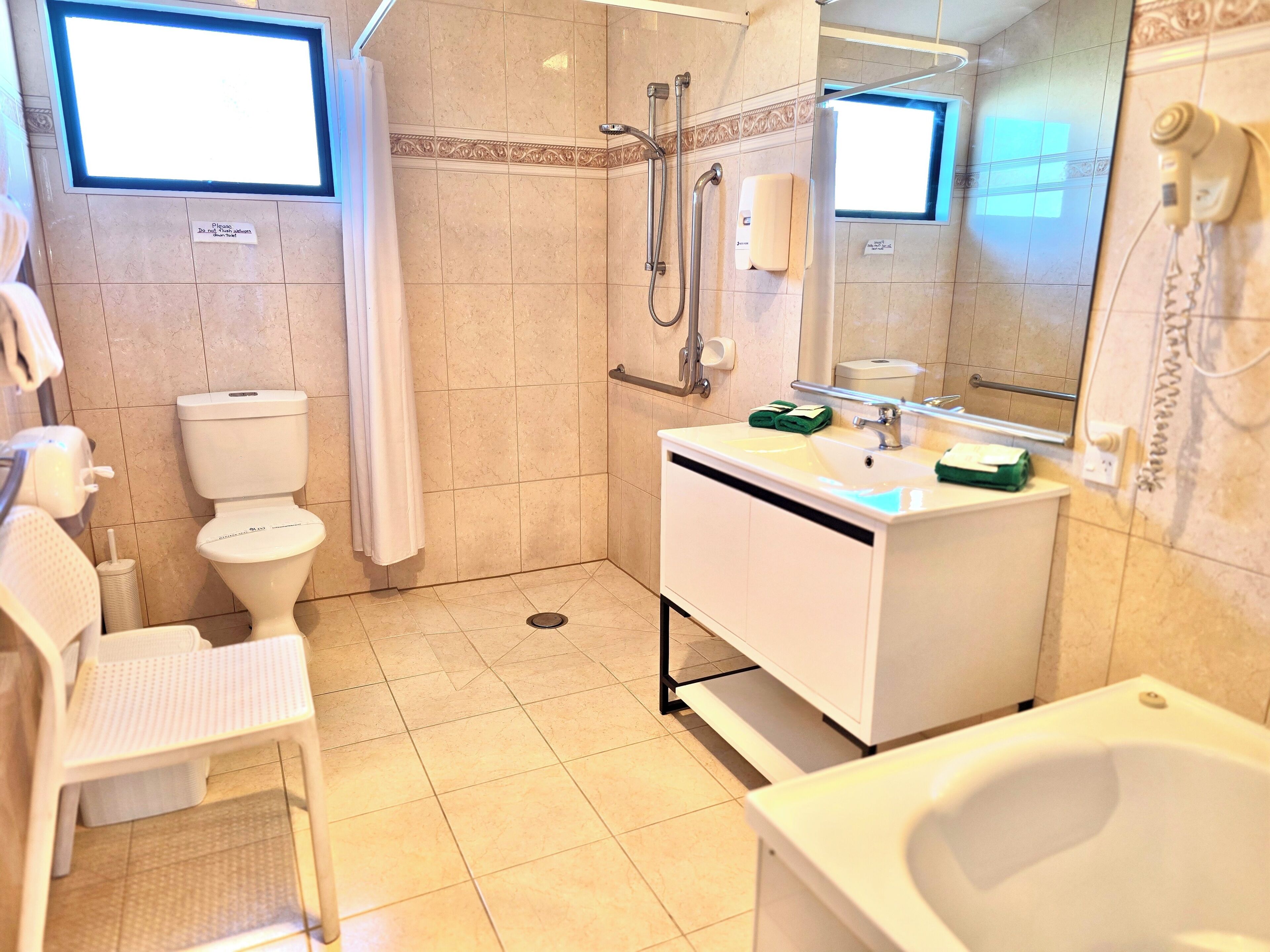 Un baño moderno con inodoro, ducha, lavabo y bañera.