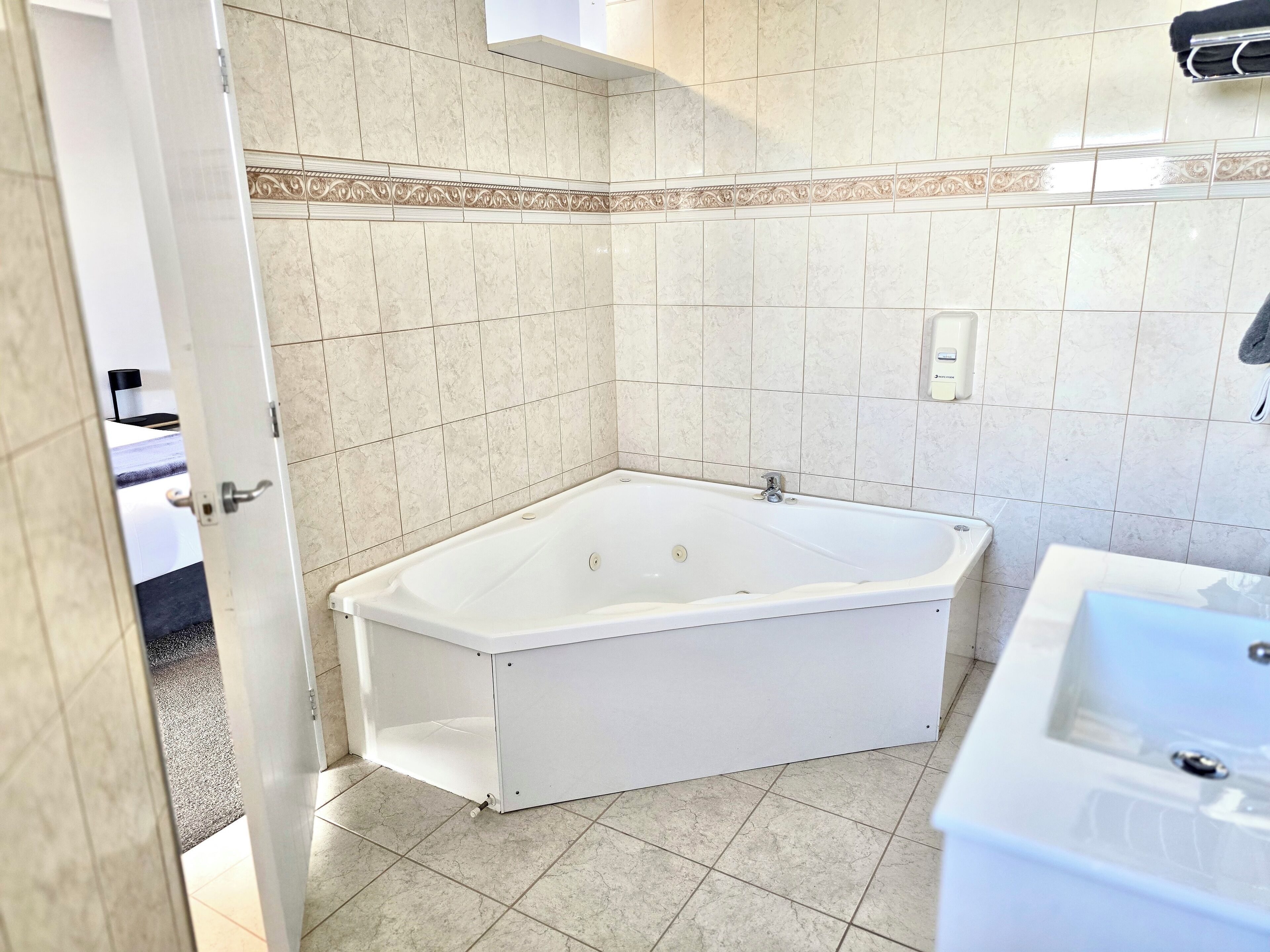 Ein Badezimmer mit einer weißen Badewanne, einem Waschbecken und einer Dusche.
