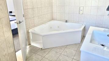 Ein Badezimmer mit einer weißen Badewanne, einem Waschbecken und einer Dusche.