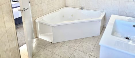 A bathroom with a white bathtub, a sink, and a shower.
