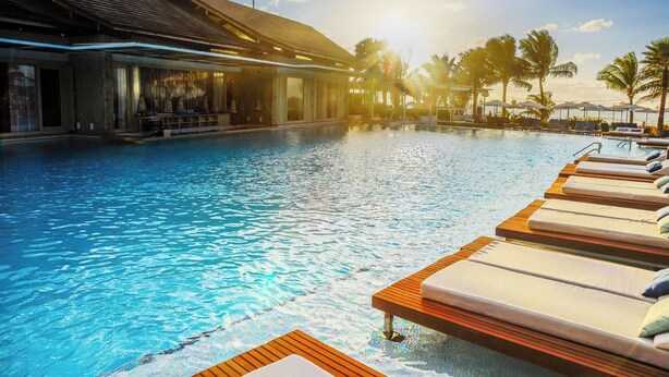 A swimming pool with lounge chairs and palm trees. - The Westin Porto de Galinhas, an All-Inclusive Resort (Ipojuca)