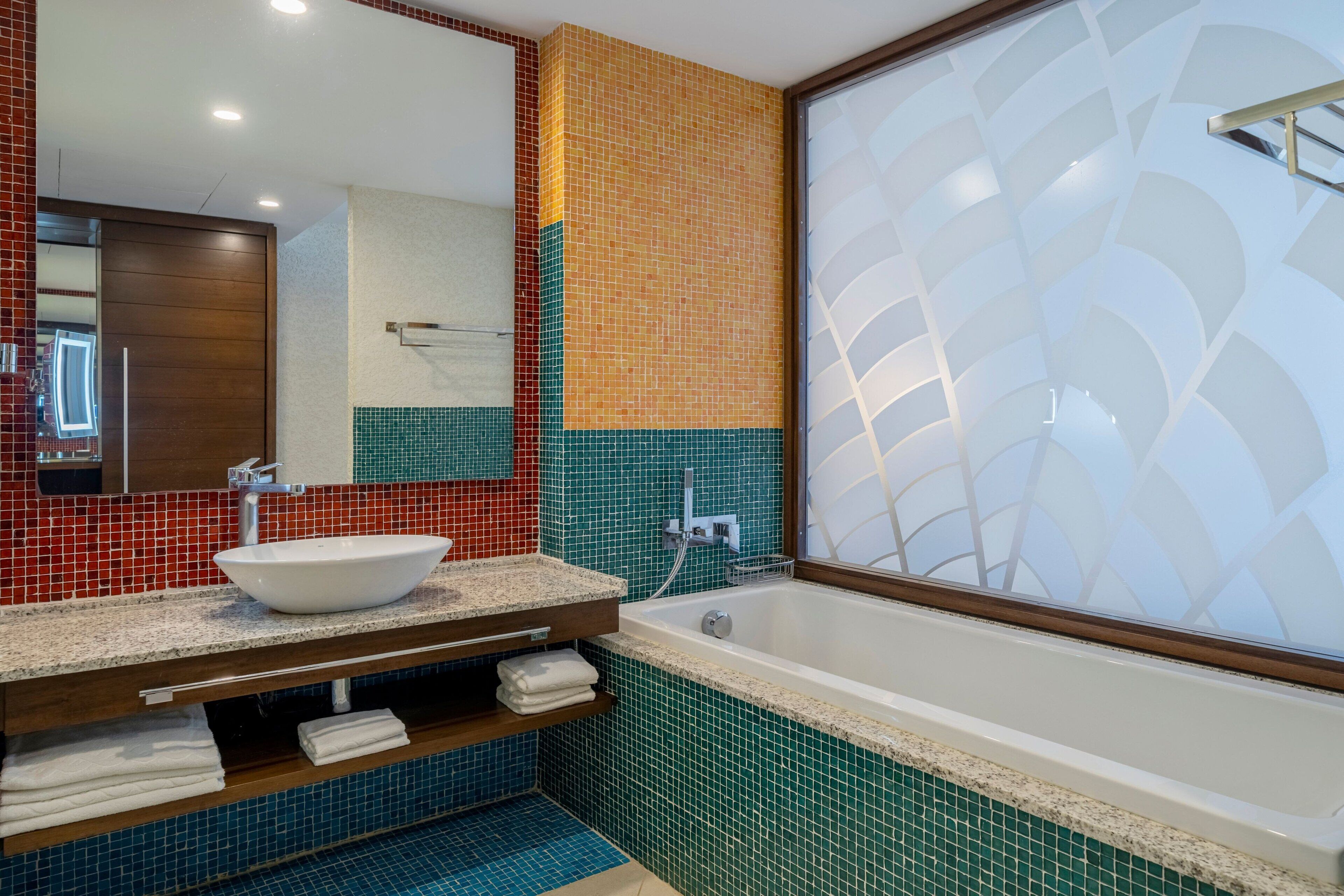 A bathroom with a white sink, a mirror, and a bathtub.
