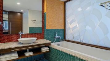 A bathroom with a white sink, a mirror, and a bathtub.