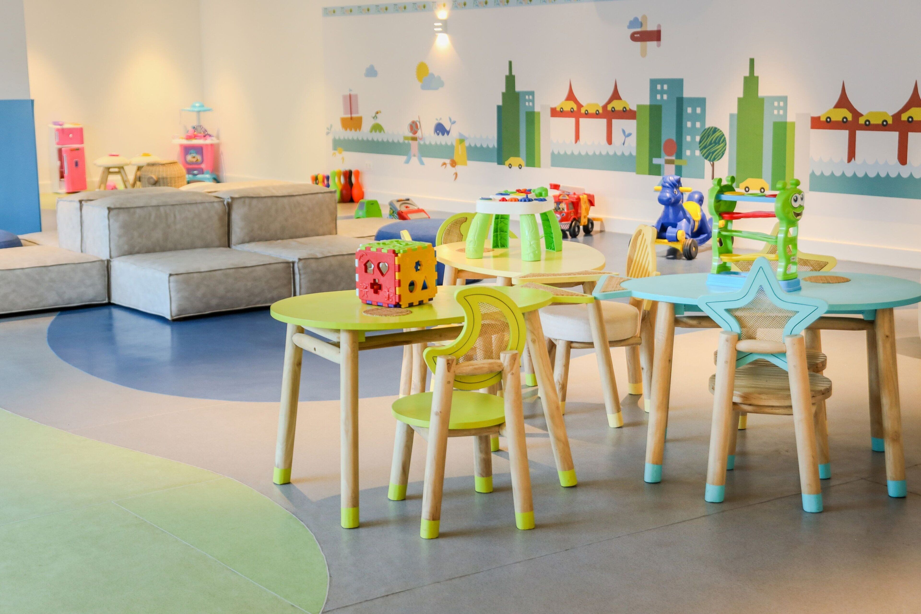 A children's play area with tables, chairs, and toys.