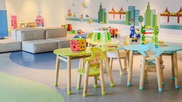 A children's play area with tables, chairs, and toys.