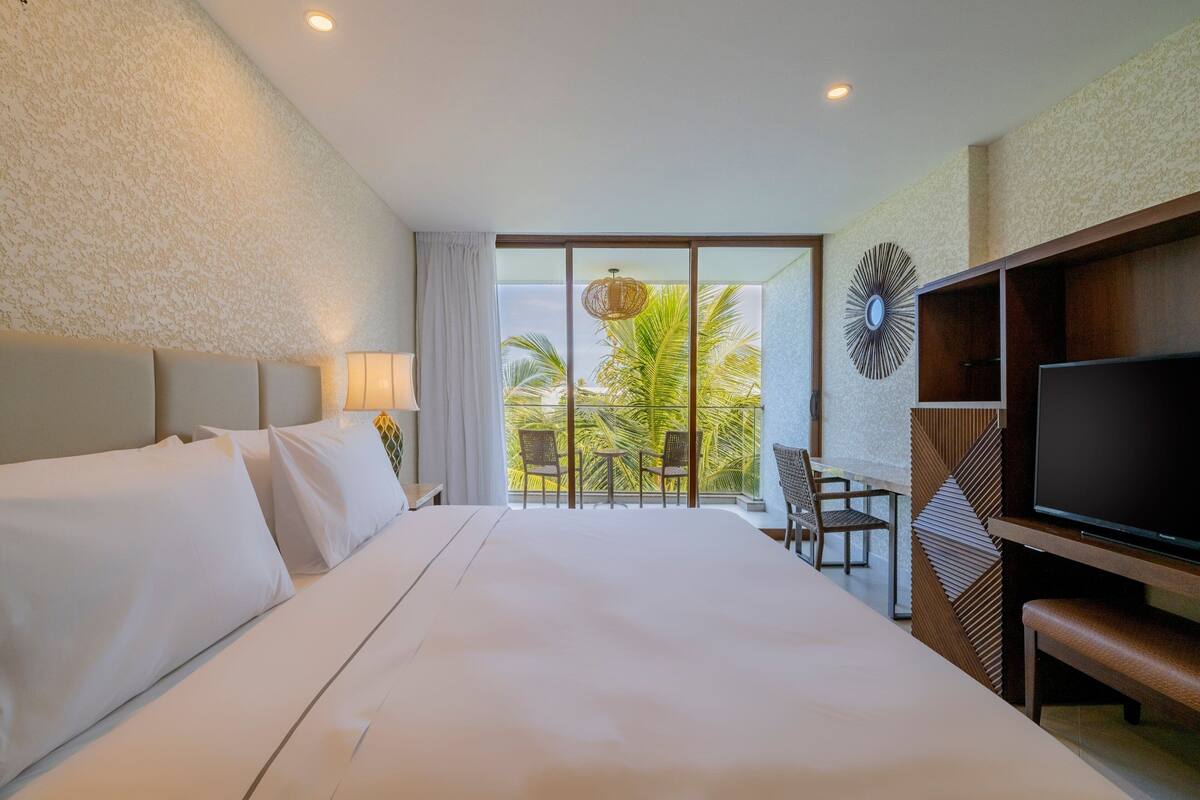 Kamar Deluks, 1 Tempat Tidur King, pemandangan kebun | Minibar, brankas, meja kerja, dan tirai kedap cahaya