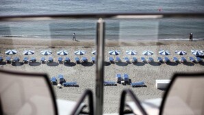 Een strand met rijen zonneschermen en ligstoelen.
